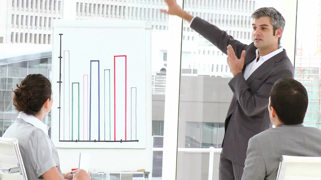 ejecutivo masculino que informa las cifras de ventas a su equipo