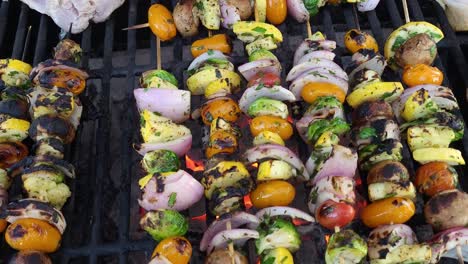 Barbecue-skewers-meat-kebabs-with-vegetables-on-flaming-grill,-close-up