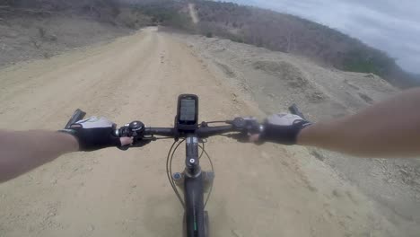 ciclista de mountainbike va muy rápido por la montaña en un camino de tierra de arena y pierde el control y choca y cae en el desierto de ecuador go pro casco tiro