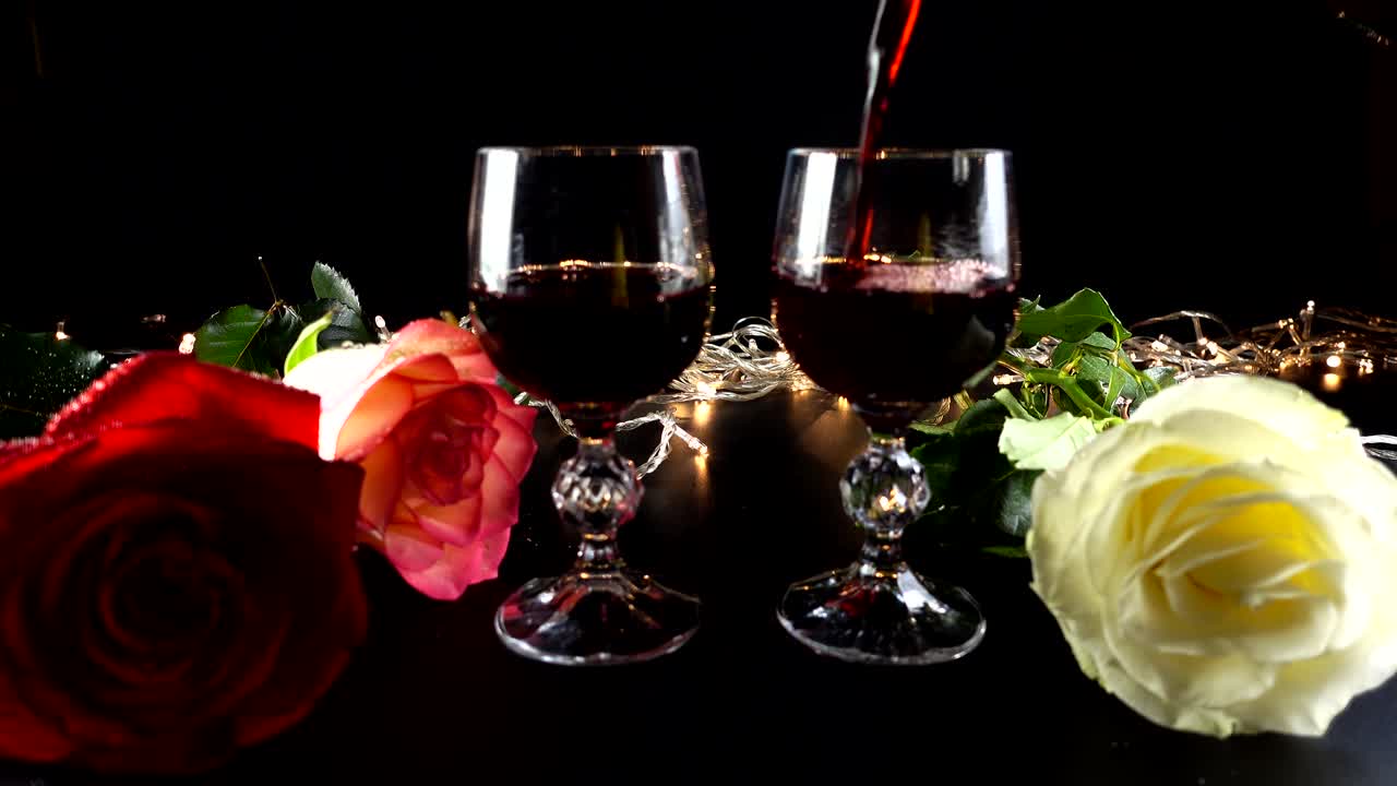 Taças de vinho e rosa contra o fundo de guirlandas brilhantes