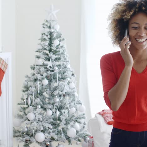 Happy-young-woman-chatting-on-her-mobile-at-Xmas