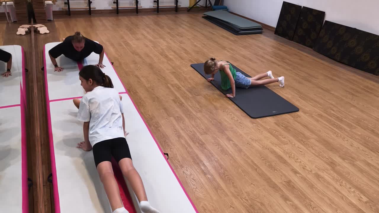 niños y adultos haciendo ejercicios de yoga en un estudio de fitness
