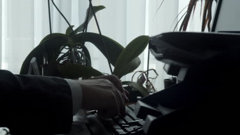 man typing on keyboard in a office close up