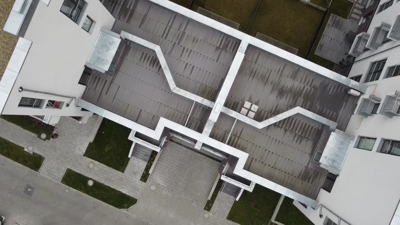 Vista aerea di un drone in volo sopra edifici residenziali, riprese di tetti e architettura.
