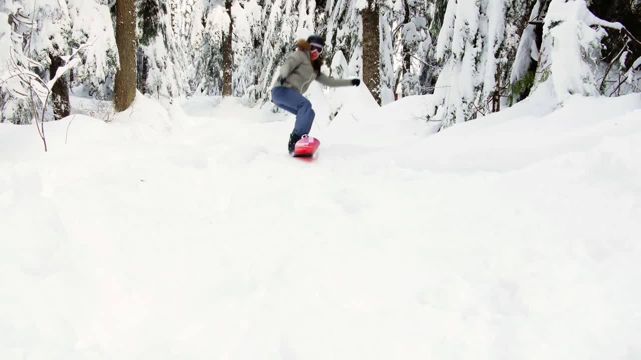 mujer haciendo snowboard en una montaña nevada 4k
