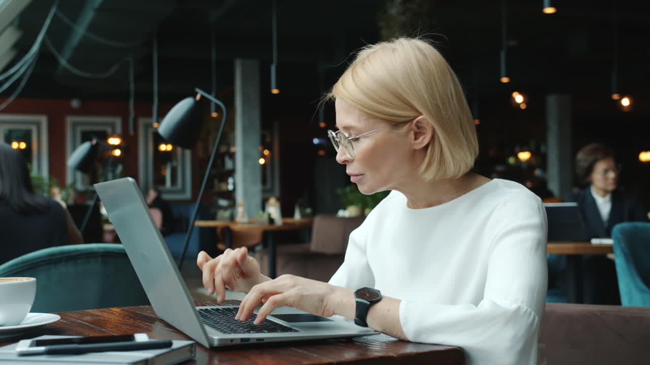 Businesswoman working on laptop in a cafe