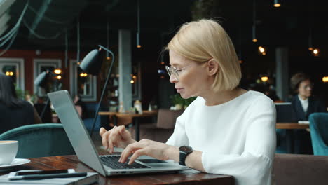 mujer de negocios trabajando en una computadora portátil en un café
