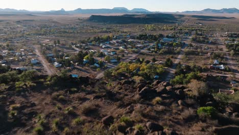 se aleja para revelar la cima de la montaña con vistas a la zona rural de texas ciudad al amanecer, fort davis en el oeste de texas pequeña ciudad hora de oro dron ciudad órbita en 4k