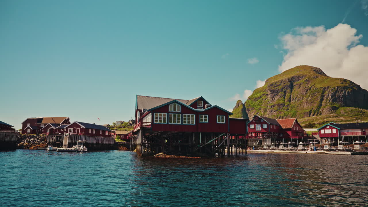 Panoramic view of the red wooden fishermen cabins in the Lofoten islands, Norway. View of the picturesque landscape in the background