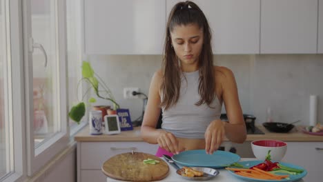 young woman preparing fresh spring rolls in a bright kitchen