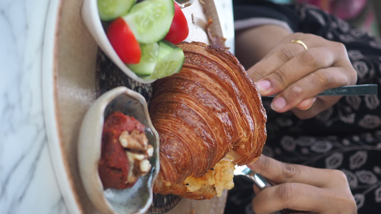 Croissant with Vegetables and a Person Eating