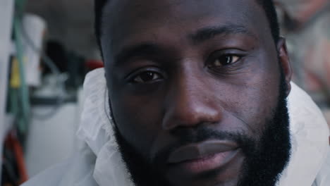 weary black paramedic taking off protective accessories tired african american doctor taking off face shield and mask and looking at camera while working in 911 service during epidemic