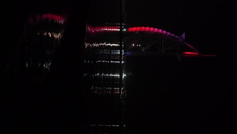 small gentle waves lapping at the shore with the burg al arab reflecting in the black still water, slow motion, vertical orientation