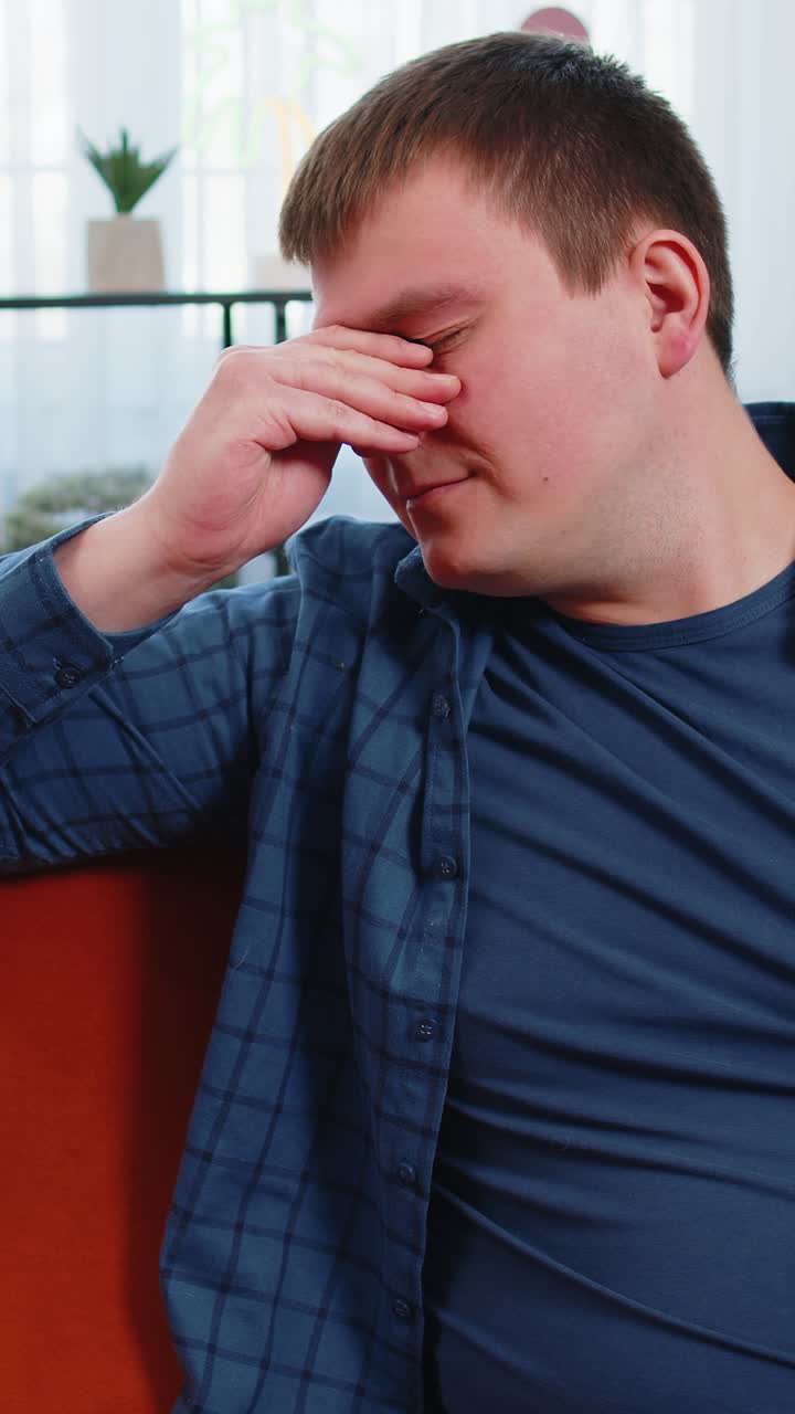 Sad lonely caucasian man depressed feeling bad annoyed disappoint hopeless sitting on home couch