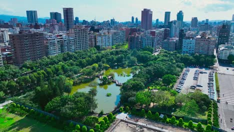 Aerial-flyover-Sun-Yat-Sen-memorial-hall-park-with-lake-and-skyline-in-background