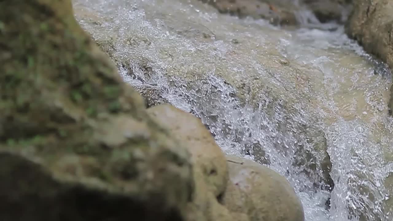 Cascata che scorre nella splendida montagna, in slow motion e zoom.