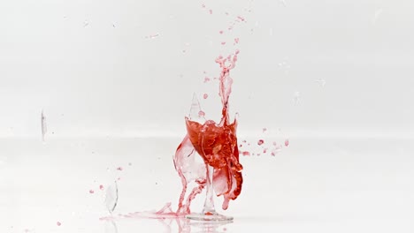 rompiendo el vaso de vino tinto en cámara lenta sobre un fondo blanco. filmado con una cámara súper lenta de 1000 fps.
