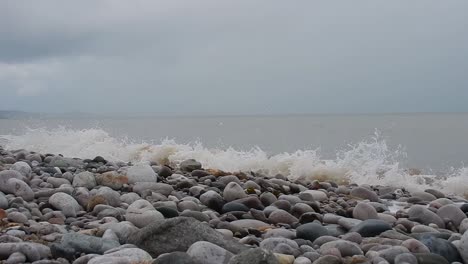 Olas-Blancas-Espumosas-Que-Se-Lavan-En-La-Costa-De-La-Playa-De-Piedra-De-Guijarros-Rocosos-Serenos-Calmantes