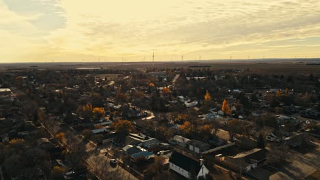 Drone-footage-of-the-quiet-streets-of-Assiniboia-Canalta,-Saskatchewan,-Canada,-featuring-a-backdrop-of-wind-turbines