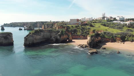 Praia-dos-Estudantes,-intimate-sand-beach-with-a-rock-tunnel,-Lagos,-Algarve