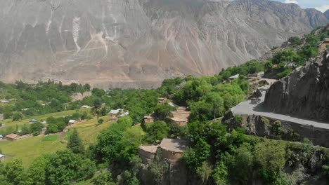 aerial over hillside winding road overlooking kalash valley in pakistan. follow shot