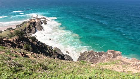 waves hitting rocky coast with lush greenery