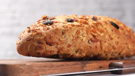 close-up of a delicious whole grain bread with oats, raisins, and nuts.