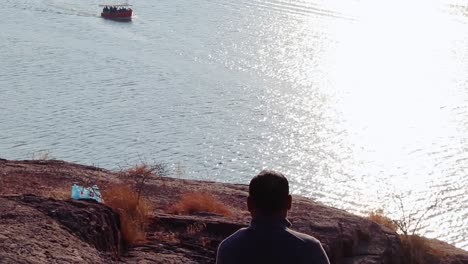 Hombre-Aislado-Sentado-En-La-Cima-De-La-Montaña-Con-Vista-Al-Lago-Desde-Un-ángulo-Plano-Se-Toma-Un-Video-En-El-Lago-Kaylana-Jodhpur-Rajasthan-India