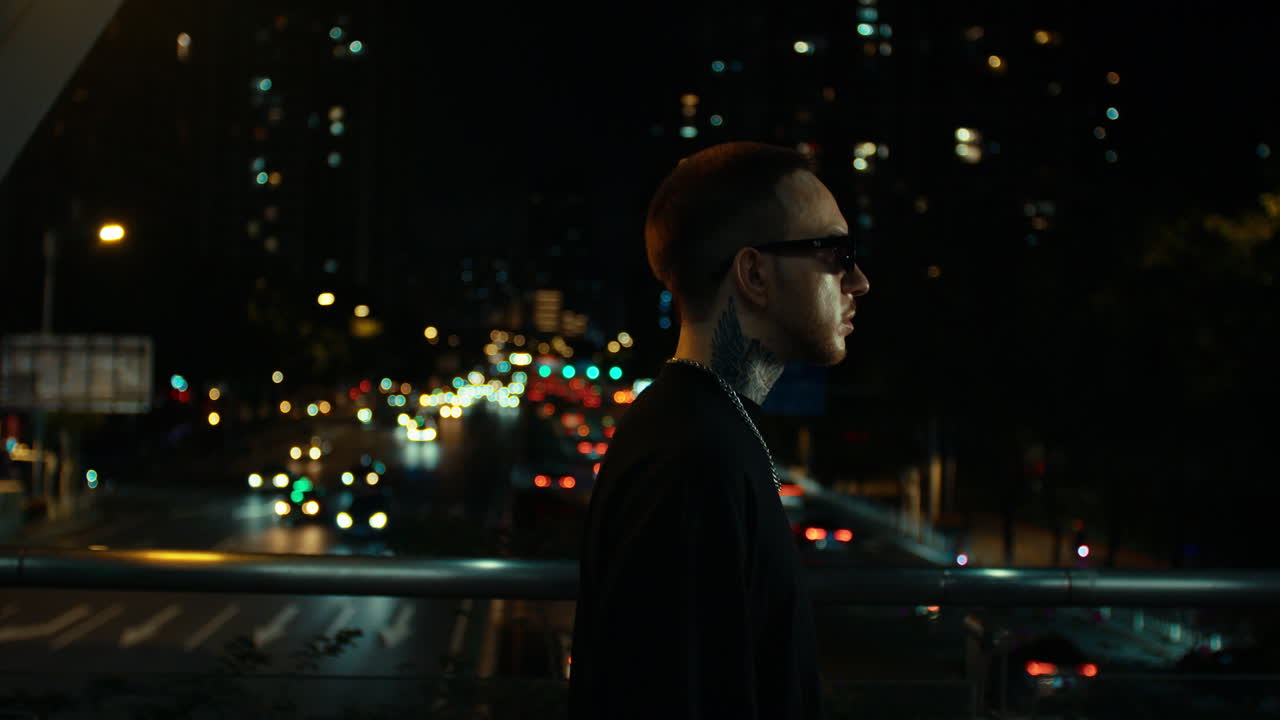 Stylish Man on Urban Overpass at Night