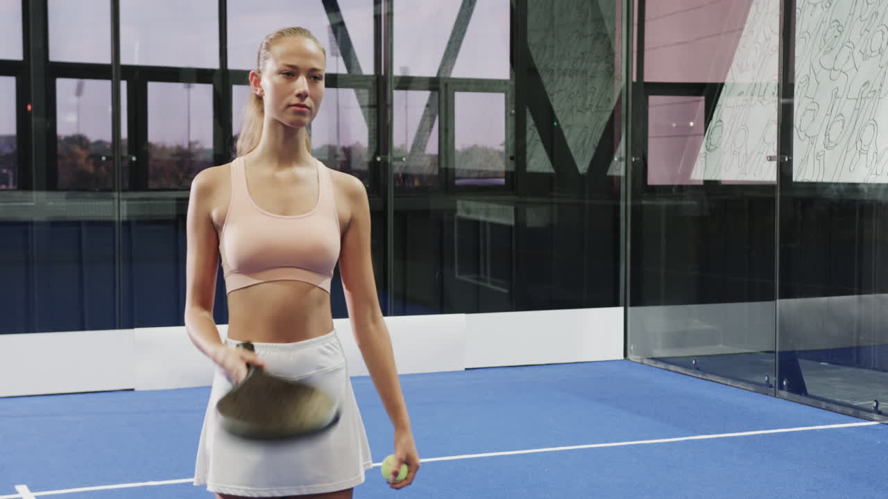 Confident woman holding padel racket on court, ready for match, copy space