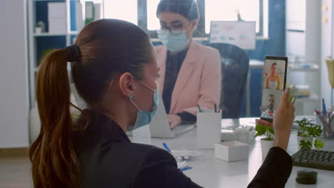 back view of freelancer man with face mask talking on videocall meeting