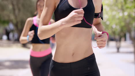 cerca de la cosecha de torso dos mujeres corriendo fitness amigos atléticos corriendo en la ciudad urbana