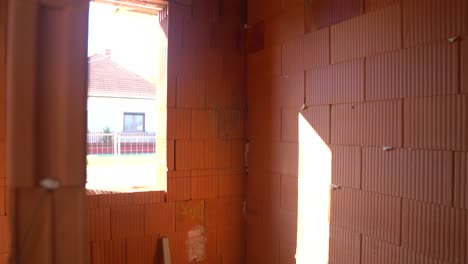 unfinished house interior with rough brick walls and window openings