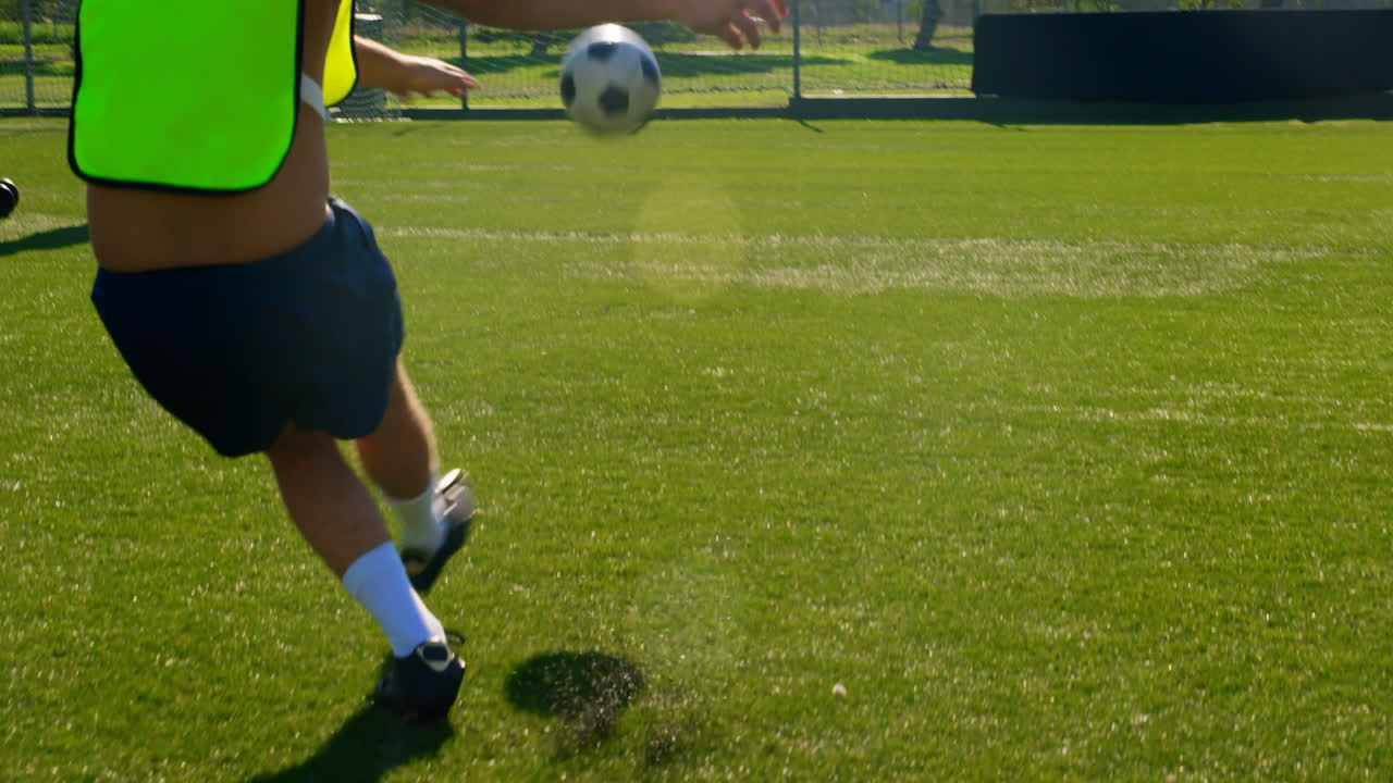 골포스트 4k 쪽으로 공을  ⁇ 고 있는 축구 선수