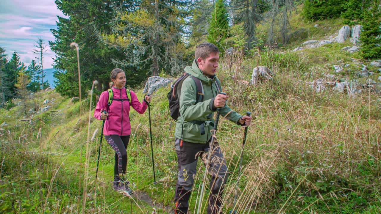 Hiking couple exploring Mount St. Ursula woods in slow motion