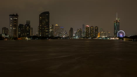 heavy rain and lightening during monsoon at the chao phraya river with bangkok city skyline
