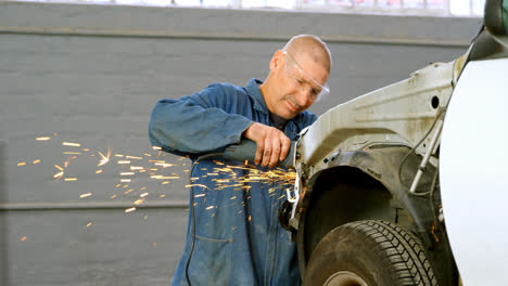 mechanic using grinding machine on a car 4k