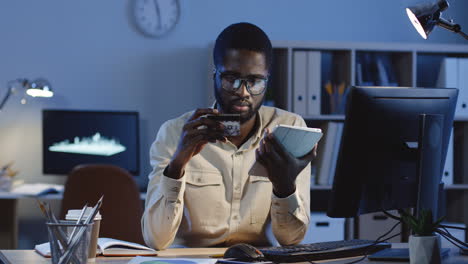 Young-Good-Looking-Man-In-Glasses-Paying-With-A-Credit-Card-While-Buying-Online-On-The-Tablet-Device-In-The-Office-Late-In-The-Evening