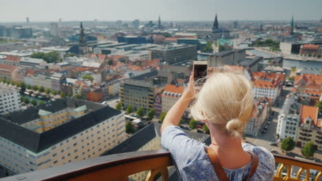 a woman takes a view from above the city of copenhagen in denmark