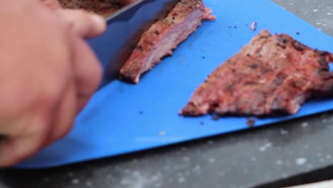 Neatly-slicing-tender-meat-on-a-blue-rubber-mat,-the-knife-easily-peeling-through-on-eat-slice