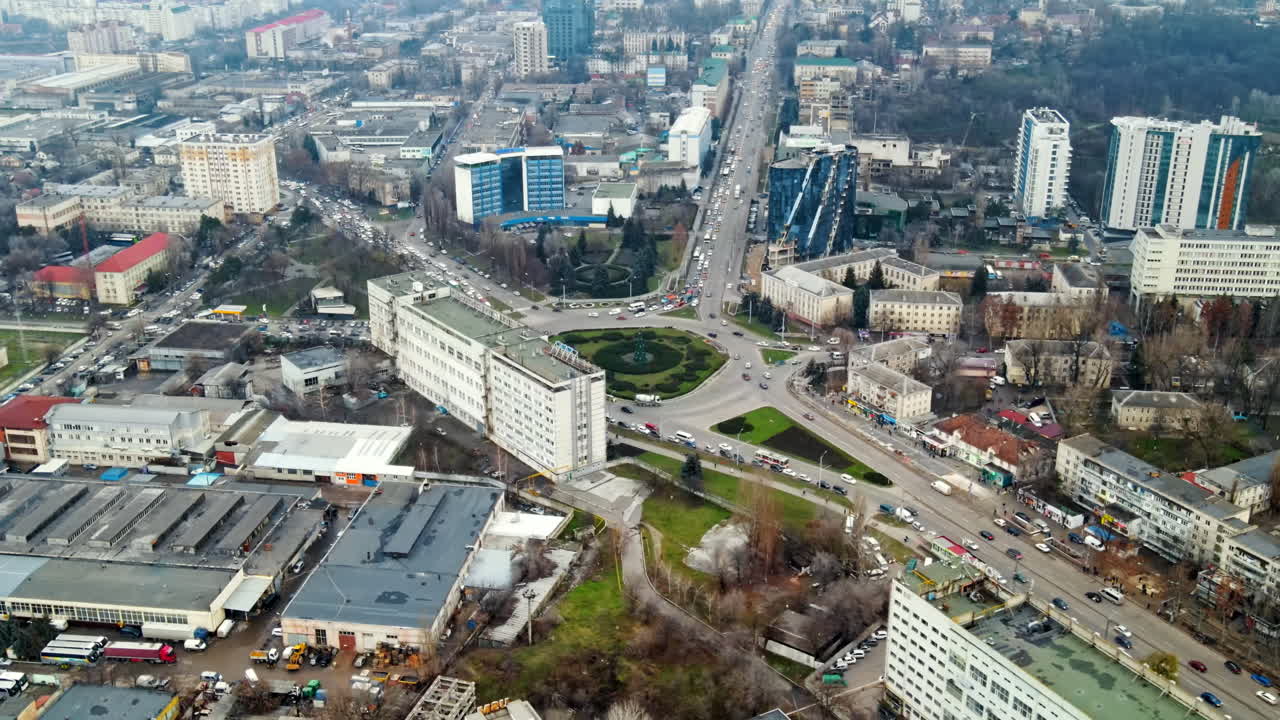Aerial drone view of Chisinau. Panorama view of multiple buildings, roads with moving cars and bare trees. Cloudy weather. Moldova