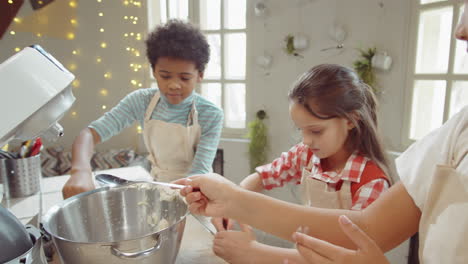 kids adding flour to mixer bowl on culinary masterclass