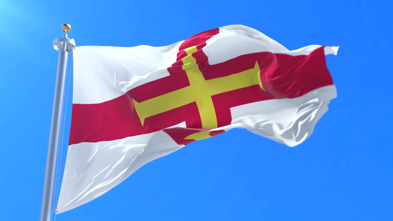 Flag of Guernsey waving at wind in slow in blue sky, loop