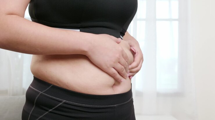 Overweight young woman in sportswear touching their belly fat overweight diet and weight loss