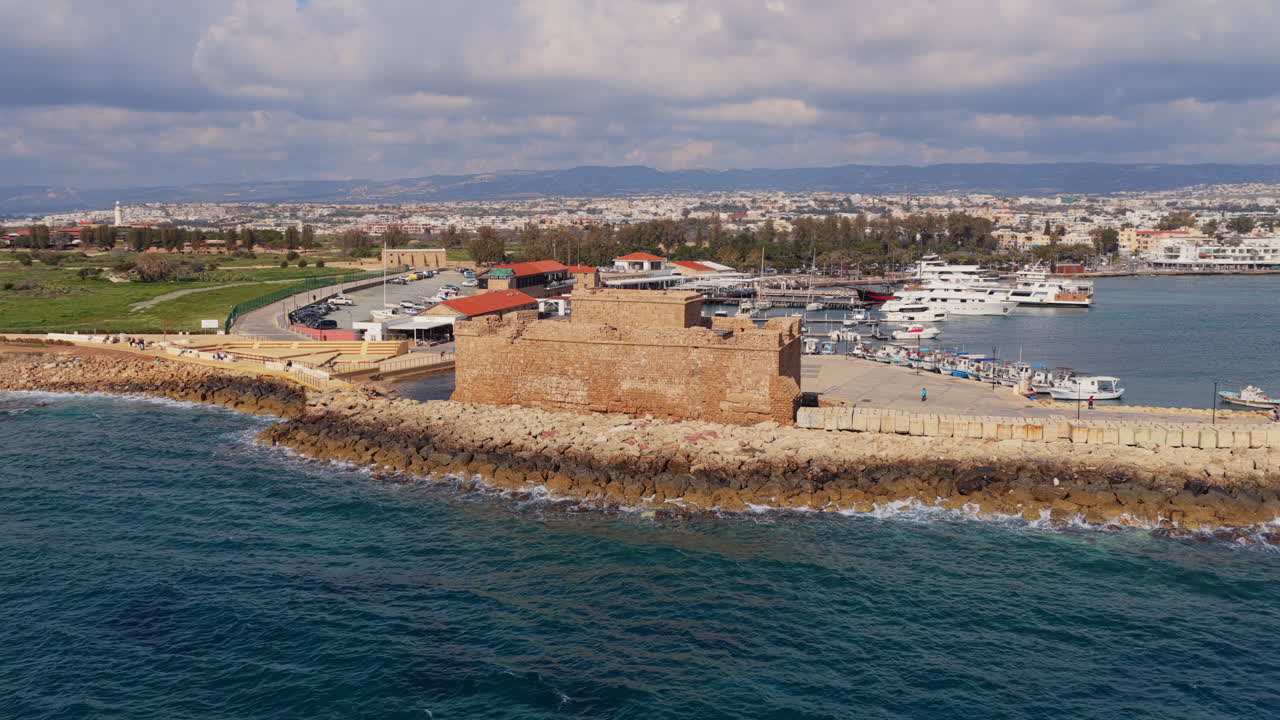 Baf Limanı'nın tarihi taş kalesi ve rıhtım boyunca uzanan tekneleriyle havadan drone görüntüsü.