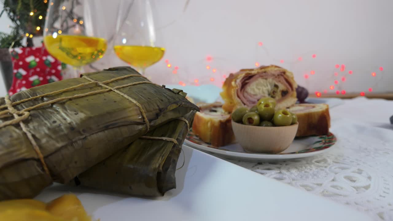 Homemade tamales served with traditional side bread and wine in a cozy setting
