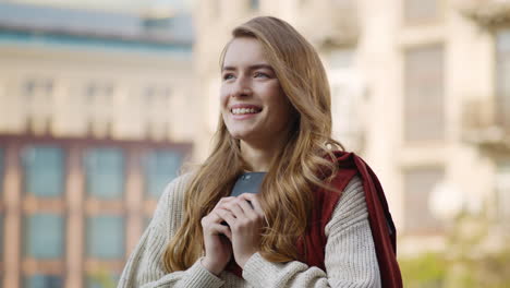 Chica-Emocionada-Mirando-La-Pantalla-Del-Teléfono-Al-Aire-Libre.-Mujer-Alegre-Sosteniendo-El-Teléfono-En-La-Calle