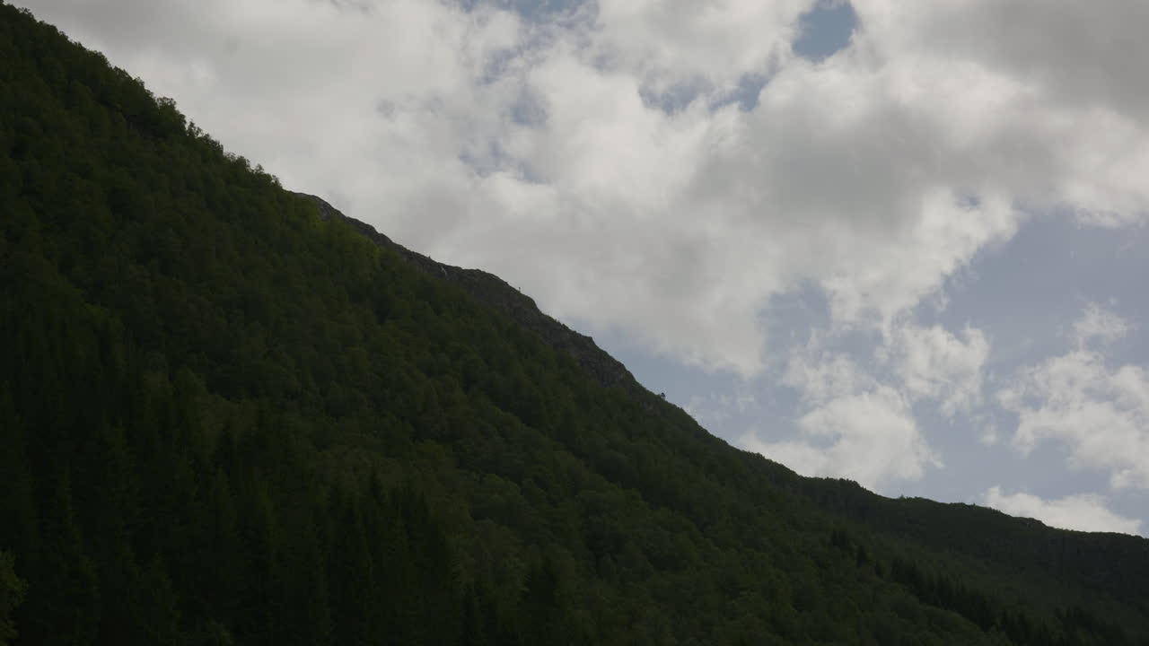 Landscape shot of the mountainside in Norway. With the sun shining and the clouds moving slowly