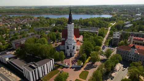 aerial shot of the city church siauliai, cathedral of saints peter and paul, on a sunny day by the river siauliai, lithuania