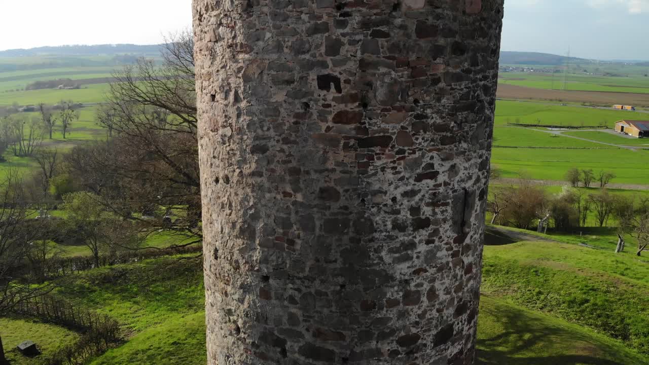 una antigua torre de vigilancia medieval aislada frente a un paisaje agrario